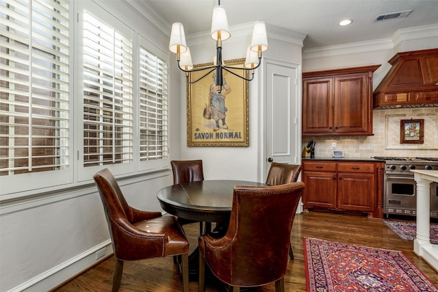 dining area with dark wood-type flooring, ornamental molding, and an inviting chandelier