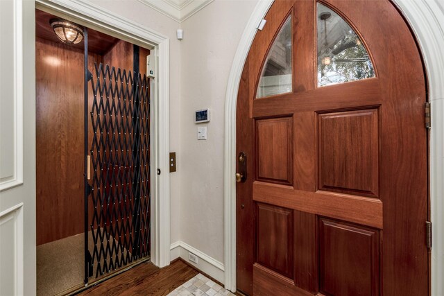 foyer entrance with light hardwood / wood-style flooring and elevator