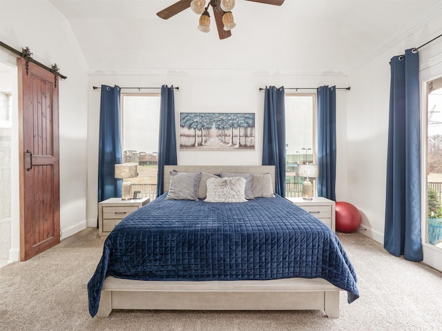 bedroom with crown molding, a barn door, and light colored carpet