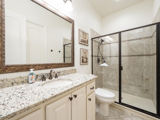 bathroom featuring vanity, toilet, a shower with shower door, and tile patterned flooring