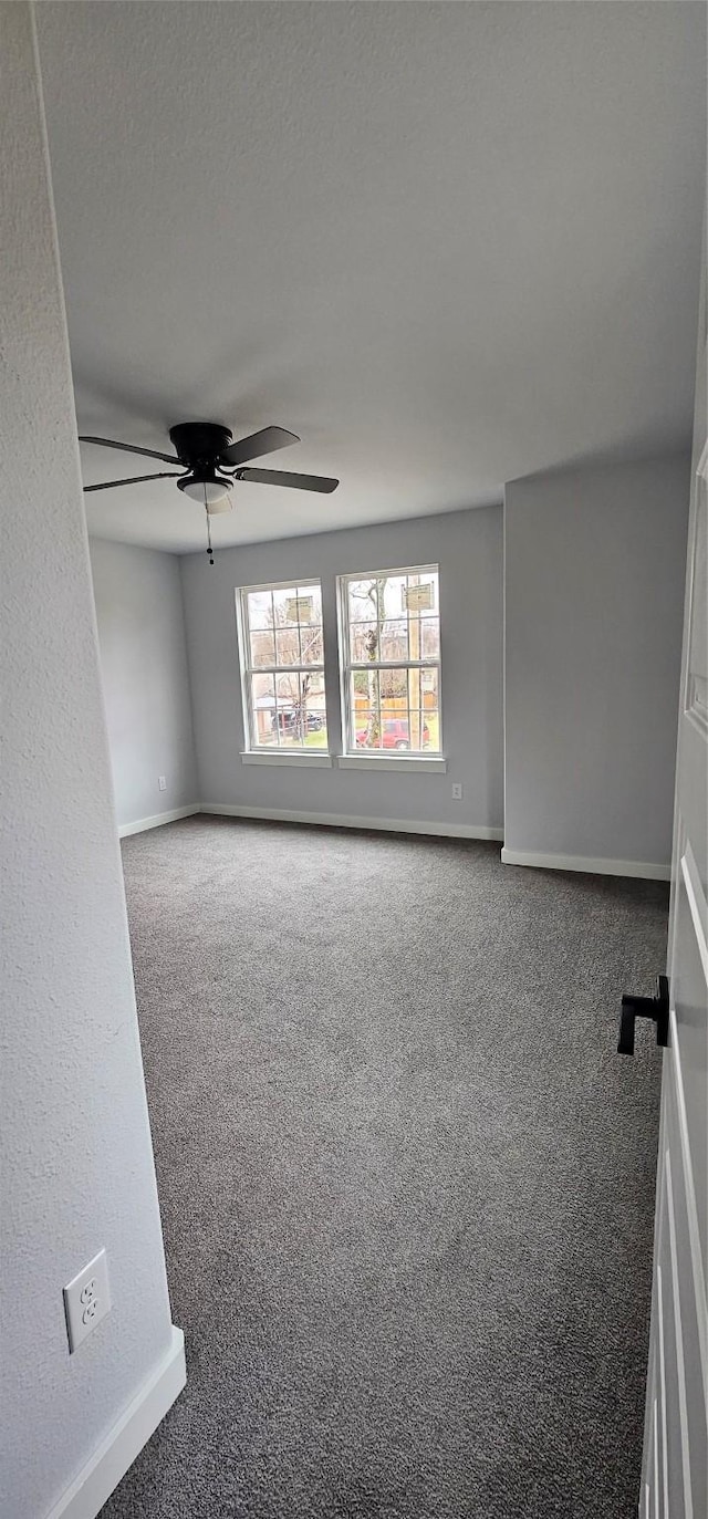 carpeted spare room featuring a textured ceiling and ceiling fan