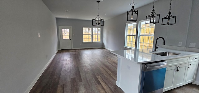 kitchen featuring sink, dark hardwood / wood-style floors, dishwasher, pendant lighting, and white cabinets