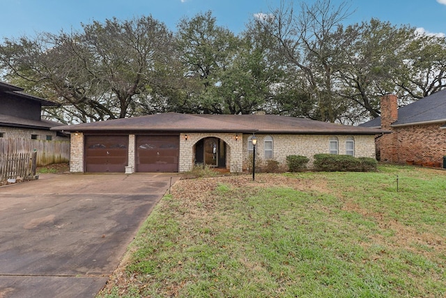 ranch-style home with concrete driveway, an attached garage, fence, stone siding, and a front lawn