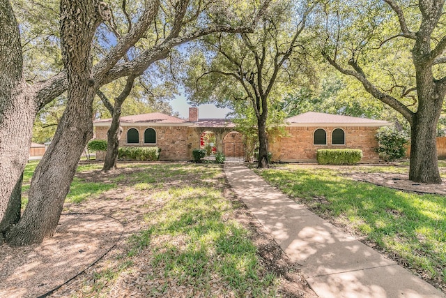 ranch-style house with brick siding and a chimney