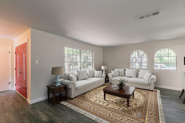 living room with dark wood-style floors, visible vents, plenty of natural light, and baseboards