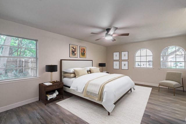 bedroom with dark wood-style floors, baseboards, and a ceiling fan