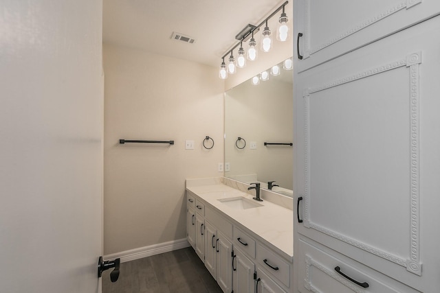 bathroom featuring visible vents, wood finished floors, vanity, and baseboards