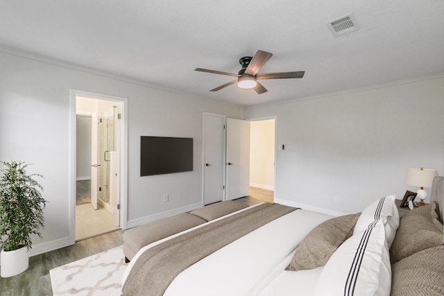 bedroom with visible vents, crown molding, and wood finished floors