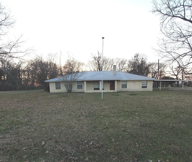 ranch-style house featuring a front yard and a chimney