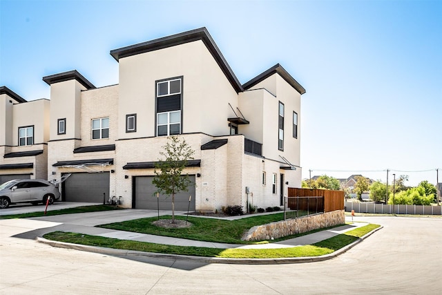 view of front of house featuring brick siding, concrete driveway, an attached garage, fence, and stucco siding