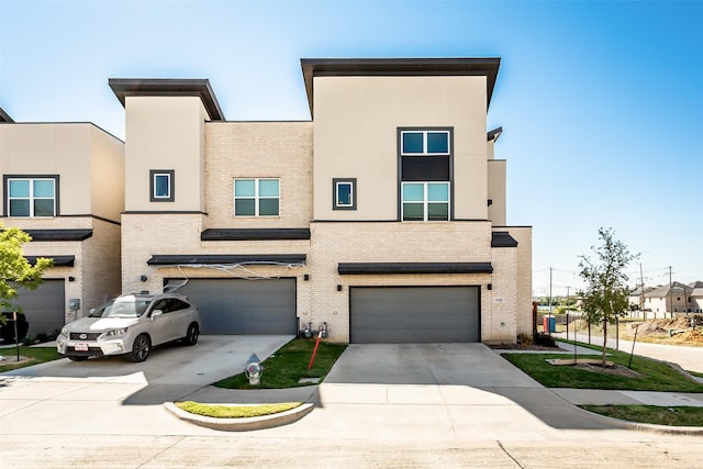 multi unit property featuring driveway, an attached garage, and brick siding