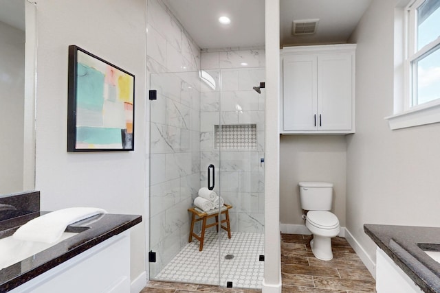 bathroom featuring a stall shower, baseboards, visible vents, toilet, and vanity