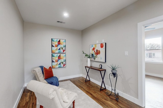 living area featuring baseboards, wood finished floors, visible vents, and recessed lighting
