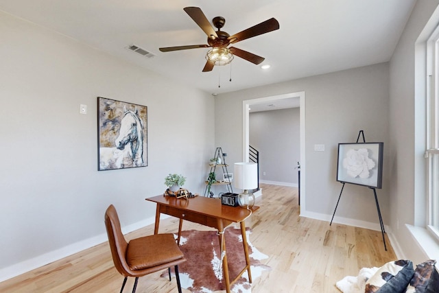 office featuring ceiling fan, baseboards, visible vents, and light wood-type flooring