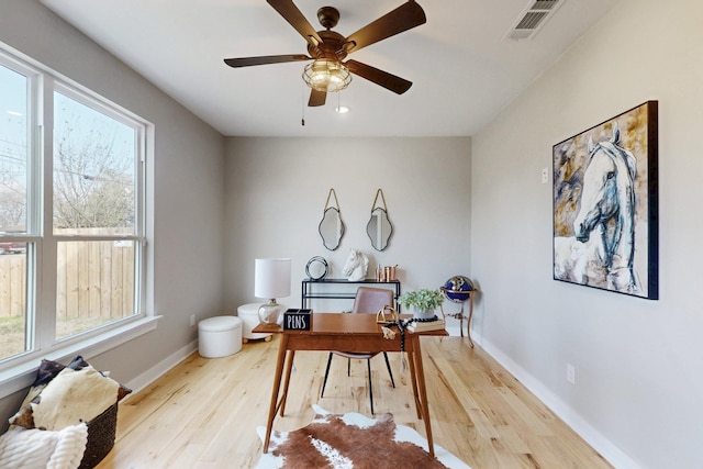 office featuring a wealth of natural light, wood finished floors, visible vents, and baseboards