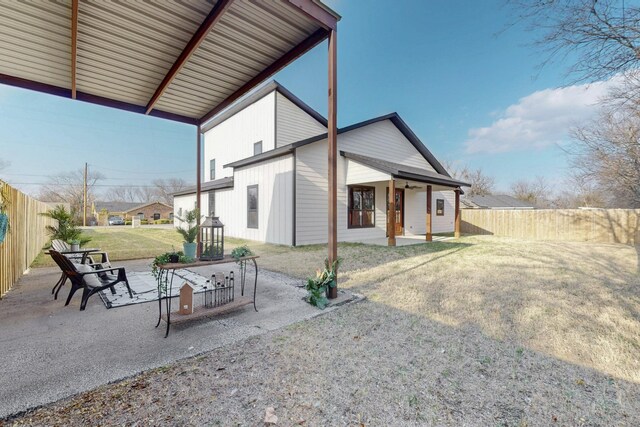 rear view of property with a yard, a fenced backyard, and a patio