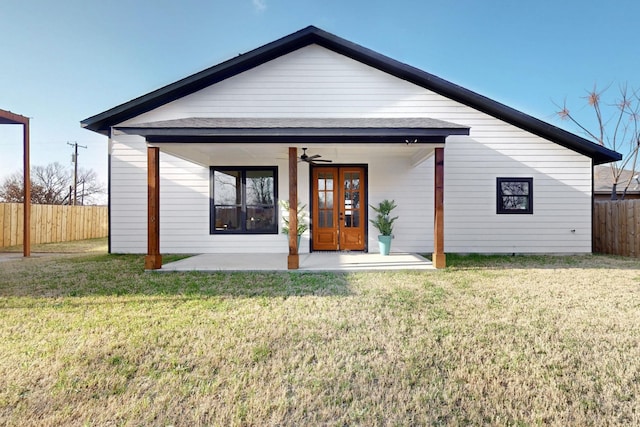 back of house with fence and a lawn