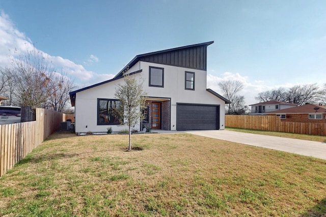view of front of house with board and batten siding, fence, a front yard, and concrete driveway