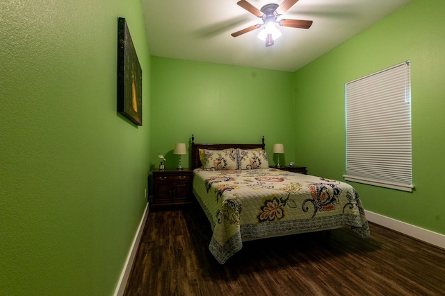 bedroom with ceiling fan, baseboards, and dark wood-type flooring