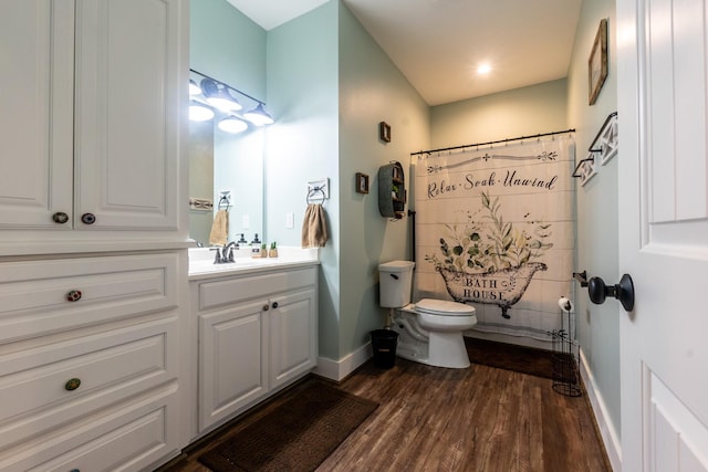 bathroom featuring a shower with shower curtain, wood finished floors, vanity, and baseboards