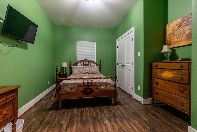 bedroom with dark wood-style floors and baseboards