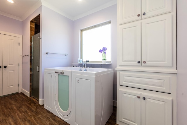 clothes washing area with ornamental molding, cabinet space, dark wood finished floors, and baseboards