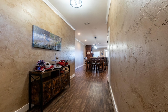 hall with a textured wall, recessed lighting, dark wood-type flooring, baseboards, and crown molding