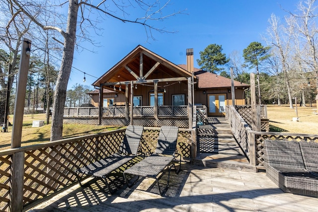 rear view of property featuring board and batten siding, roof with shingles, and ceiling fan