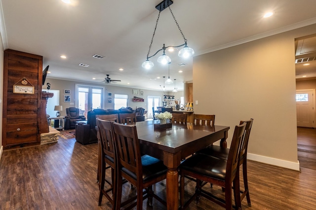 dining area featuring dark wood-style floors, visible vents, baseboards, and crown molding