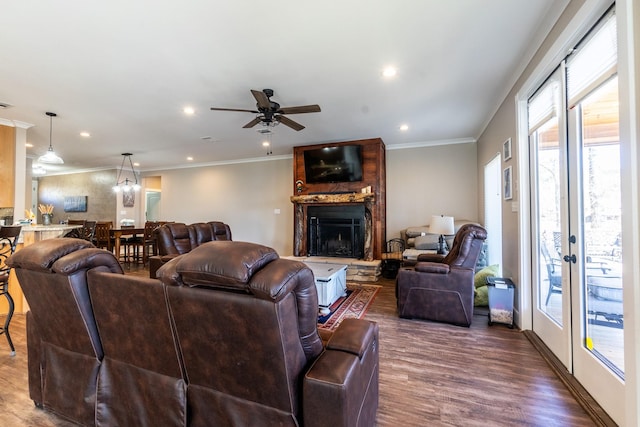 living room with a large fireplace, ornamental molding, wood finished floors, and recessed lighting