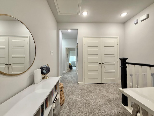 hallway with baseboards, recessed lighting, and light carpet