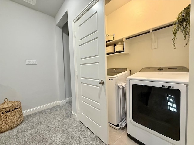 clothes washing area with laundry area, baseboards, washer and dryer, and light colored carpet