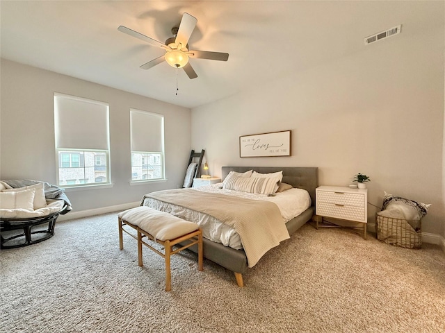 carpeted bedroom featuring baseboards, visible vents, and ceiling fan