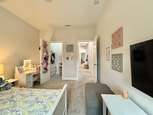 bedroom featuring baseboards, visible vents, light carpet, and a spacious closet