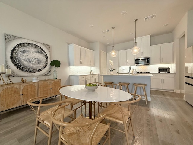 dining space featuring visible vents and wood finished floors