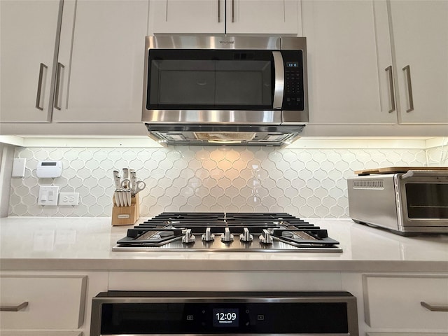 details featuring white cabinets, stainless steel appliances, and backsplash