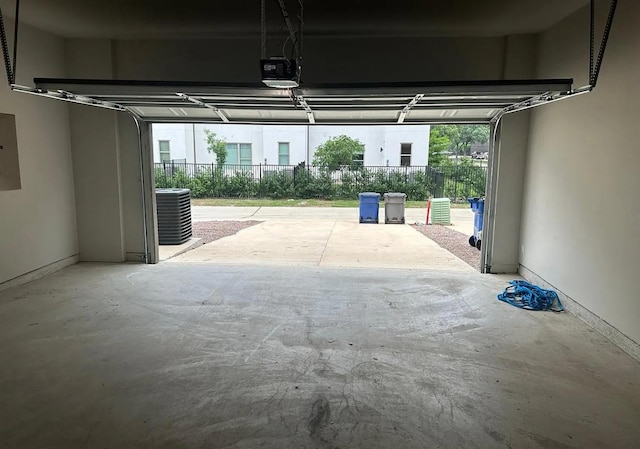 garage with electric panel, central air condition unit, and a garage door opener