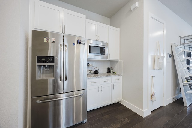 kitchen with appliances with stainless steel finishes, dark wood-style flooring, and white cabinets