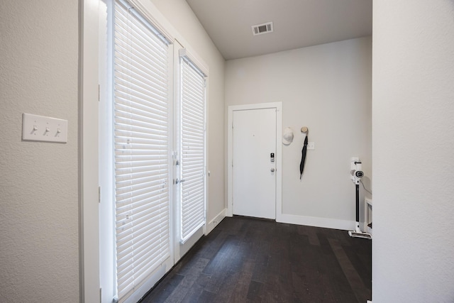 doorway to outside with visible vents, dark wood finished floors, and baseboards