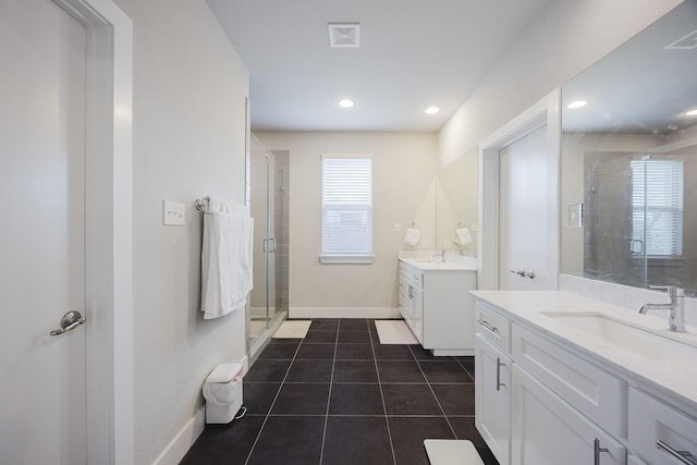 bathroom featuring two vanities, a sink, baseboards, tile patterned floors, and a stall shower