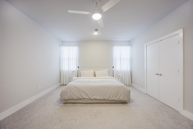 bedroom featuring baseboards, ceiling fan, visible vents, and light colored carpet