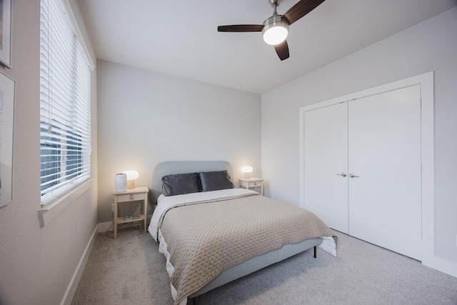 carpeted bedroom featuring a closet, a ceiling fan, and baseboards