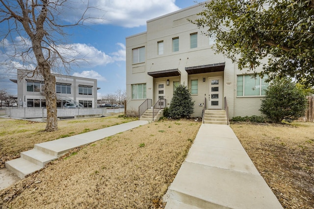 view of front of house with a front yard and brick siding