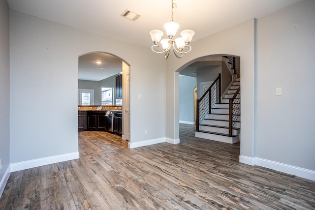 unfurnished dining area with an inviting chandelier and hardwood / wood-style floors