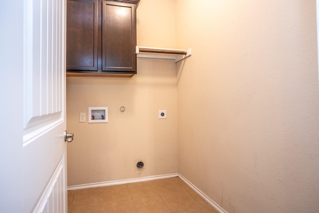 laundry area with hookup for a gas dryer, cabinets, washer hookup, light tile patterned floors, and hookup for an electric dryer