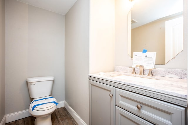 bathroom with vanity, toilet, and hardwood / wood-style floors