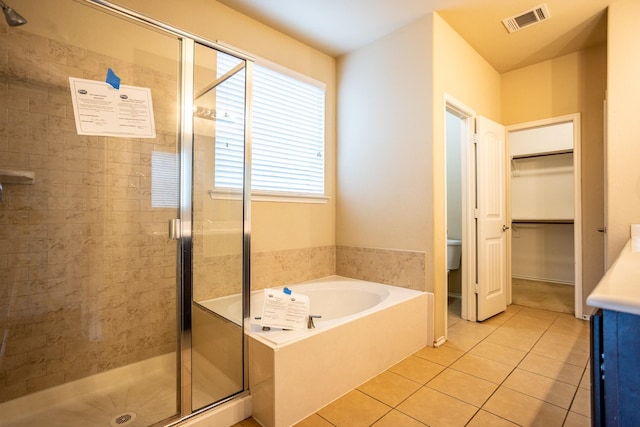 full bathroom featuring toilet, tile patterned floors, shower with separate bathtub, and vanity