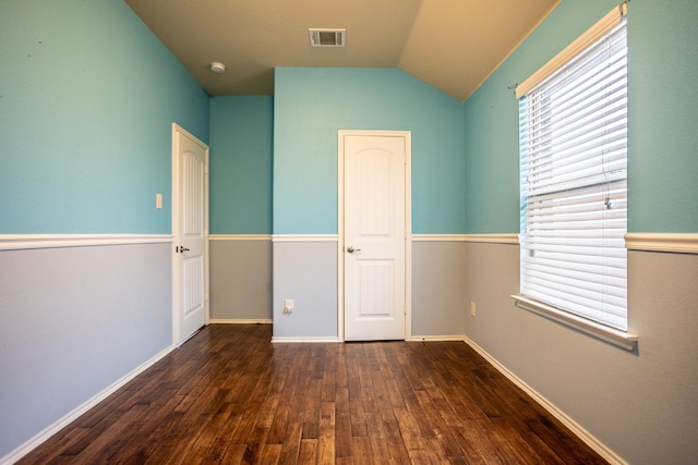 spare room featuring dark hardwood / wood-style floors and vaulted ceiling