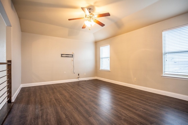 unfurnished room featuring dark hardwood / wood-style flooring, vaulted ceiling, a wall mounted AC, and ceiling fan