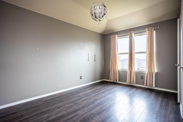 spare room with vaulted ceiling and dark hardwood / wood-style floors